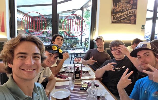 Six study abroad students sat at a table in a restaurant and smiling at the camera