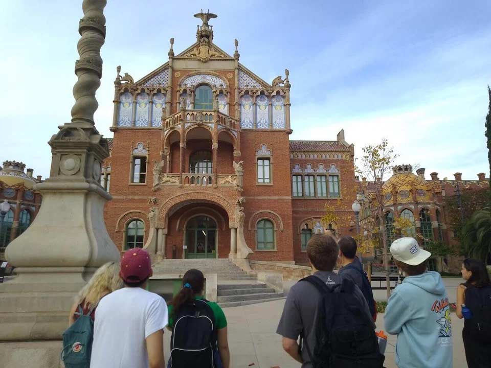 Students having a discussion outside L'Hospital de La Santa Creu i Sant Pau in Barcelona, Spain