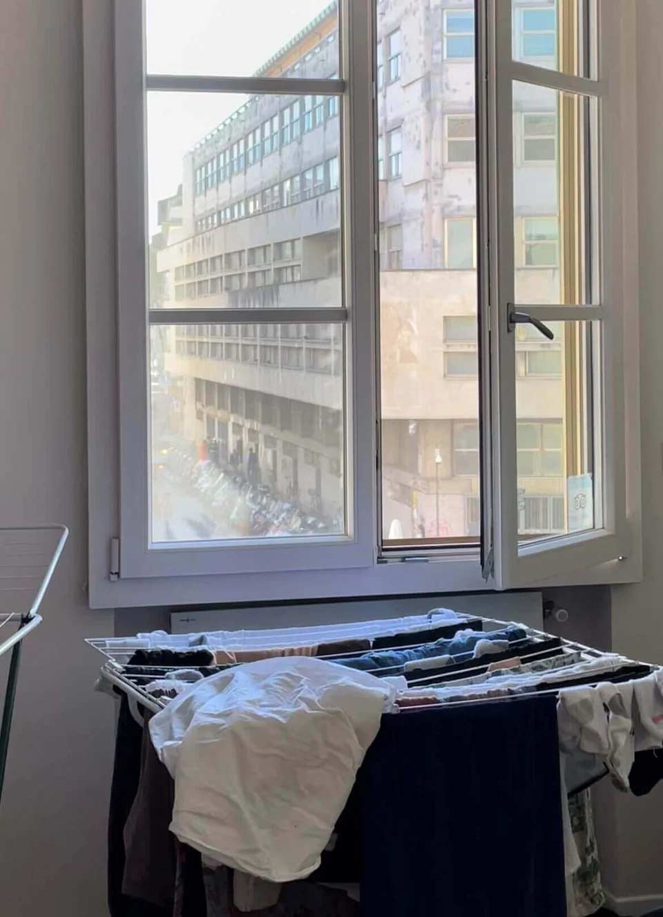 Clothes on a drying rack in front of a window