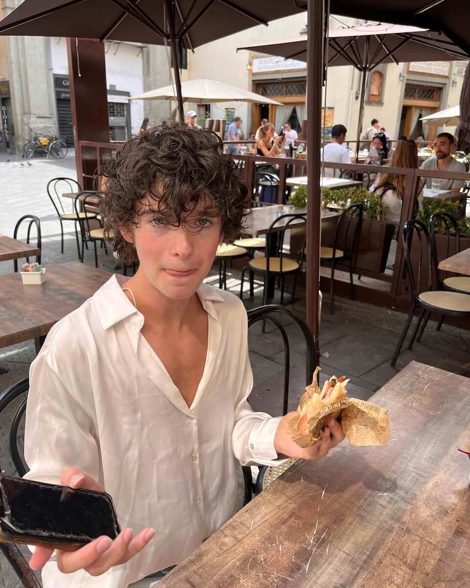 William eating a panino wearing a Zara shirt he purchased in Florence