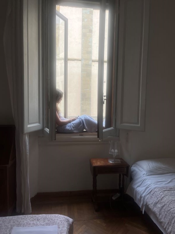 Study abroad student sitting in window of room