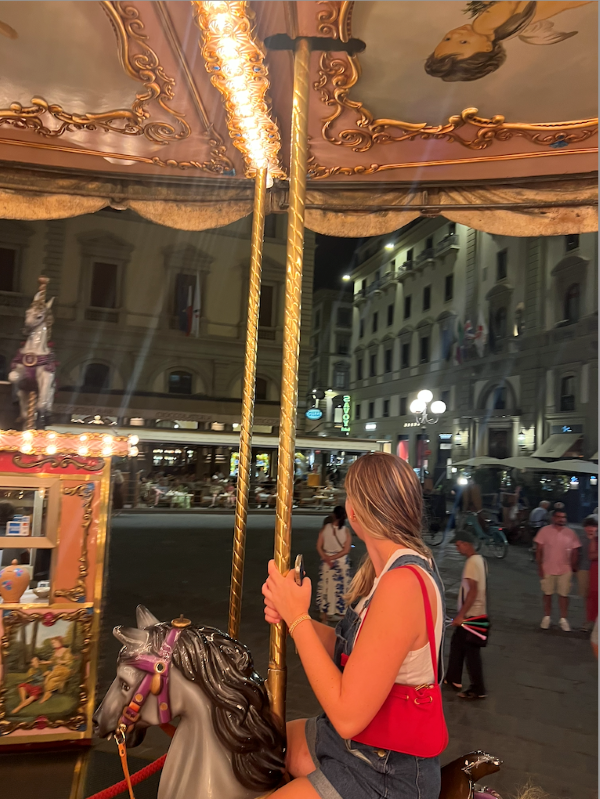 Study abroad student riding carousel at night