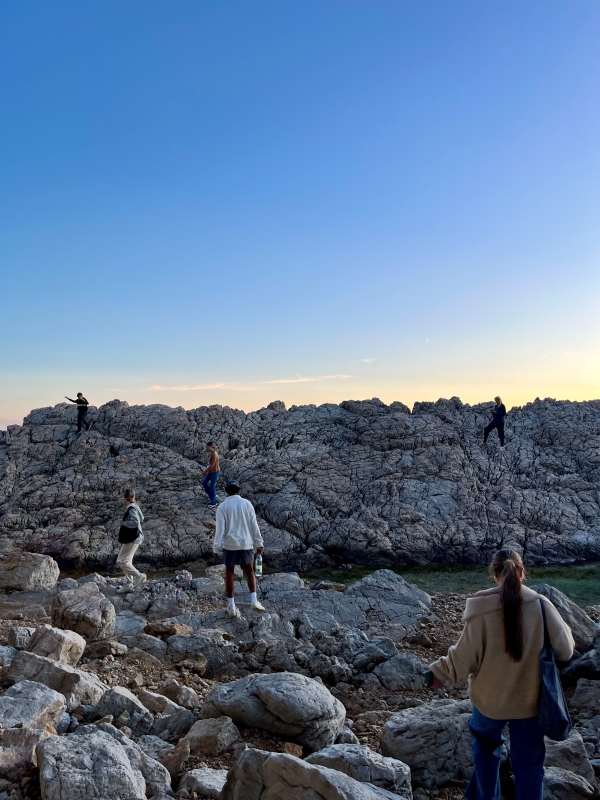 Group of study abroad students walking on rocky coast