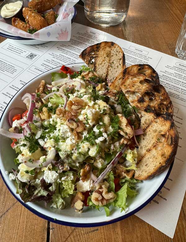 A plate of salad and bread on a table
