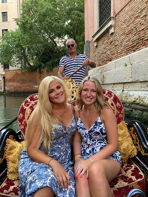 Two friends sitting in Gondola in Italian canal