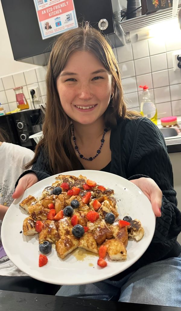 Study abroad student holding a plate of homemade french toast
