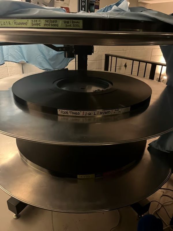 A stack of film reels resting on a small table in an indoor setting.