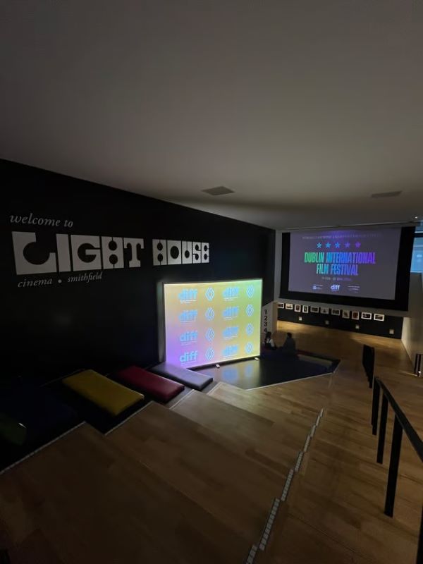 An indoor room shown in low lighting, featuring a few bright screens