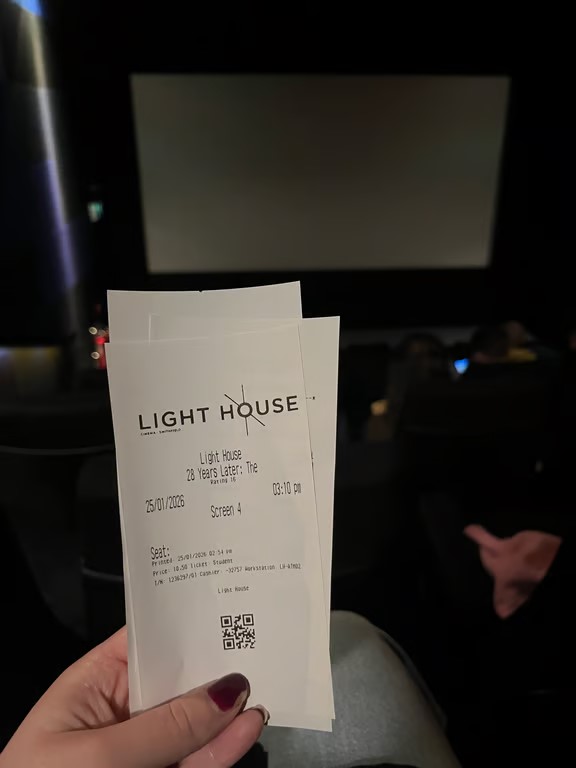 A hand holding a white receipt featuring the words