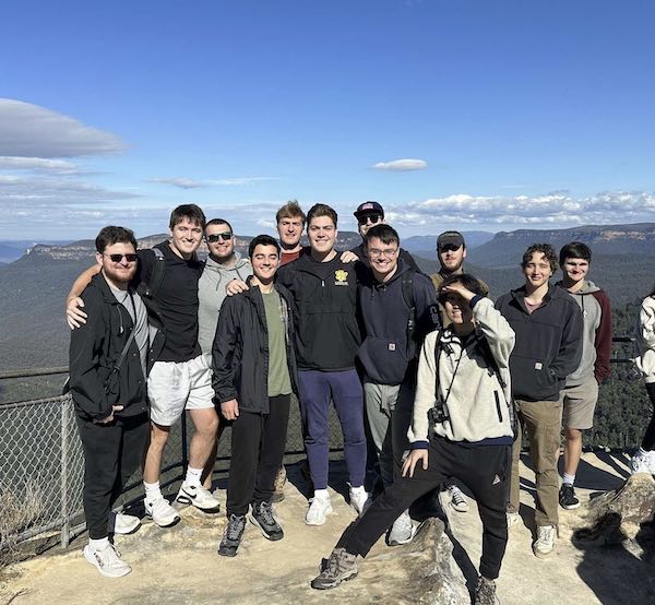 group of people standing on mountain lookout