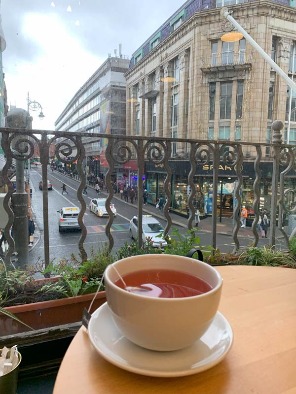 A cup of tea on a table outside.
