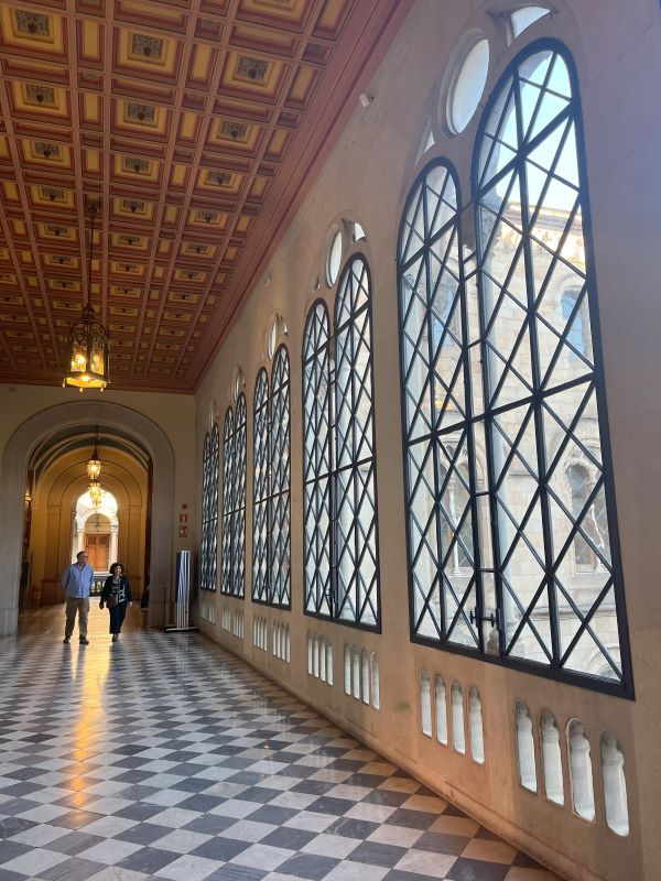 Interior photo of  la Universitat de Barcelona with large windows and checkered floor