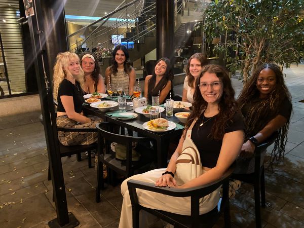 Seven study abroad students sitting at restaurant table for dinner