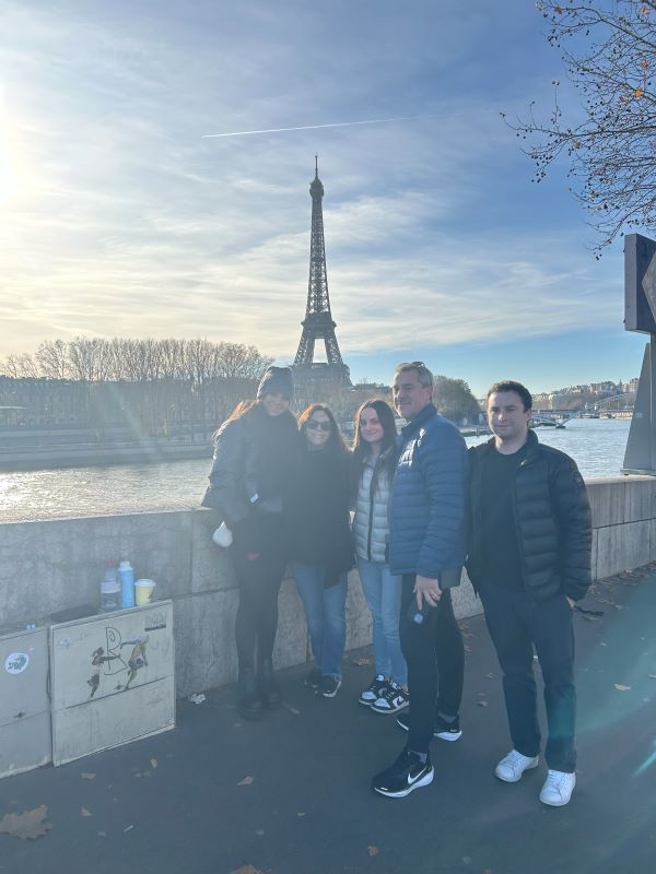 Study abroad student and family posing for photo with the Eiffel Tower in background