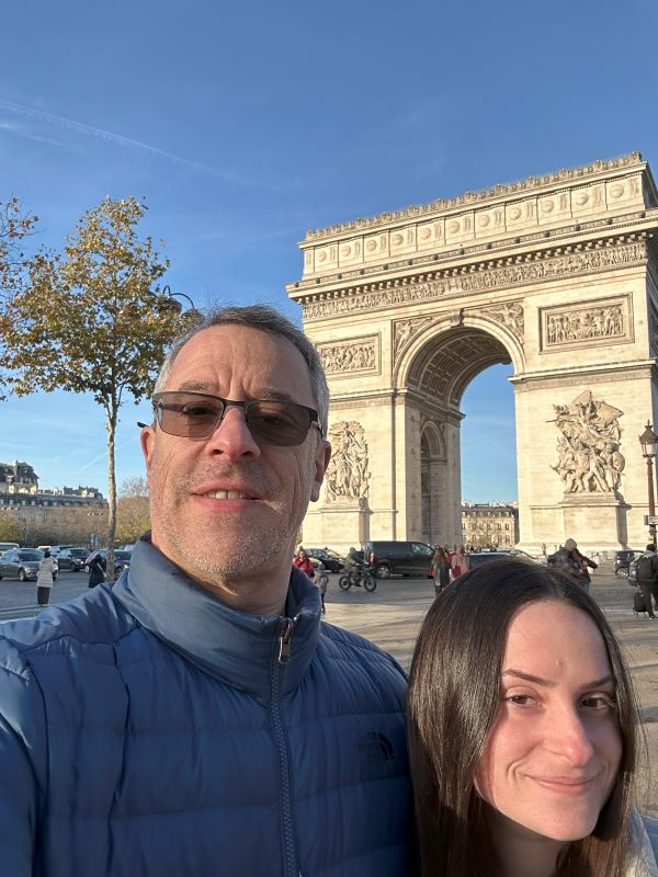 Selfie of study abroad student with dad in front of arch monument