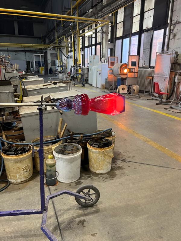 A piece of glass in the process of being blown in an indoor work space