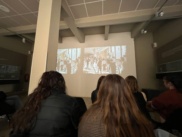 A group of study abroad students staring at an image on a large screen