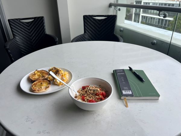 Photo of yogurt bowl and plated eggs and english muffin
