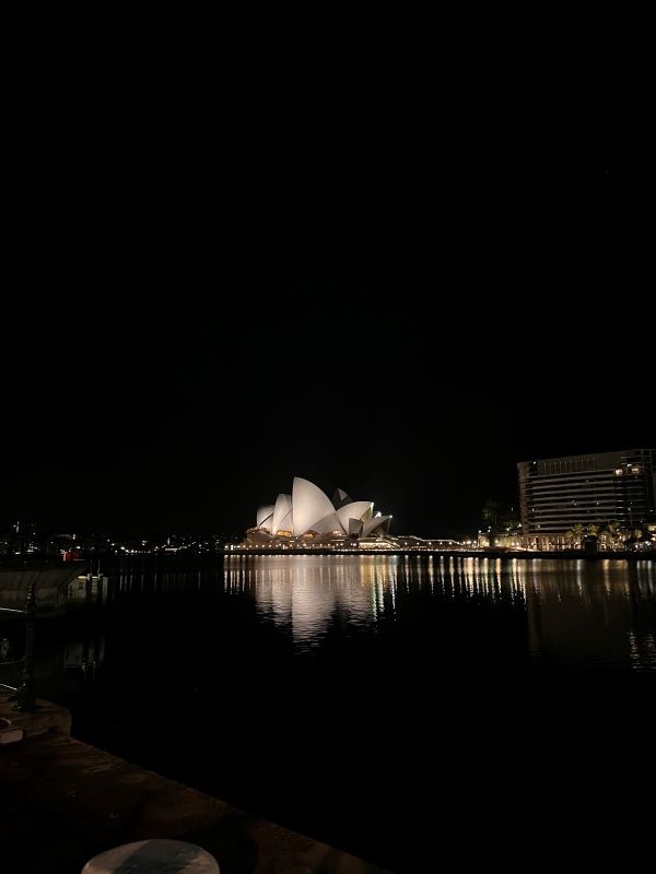Sydney Opera House lit up at night from afar