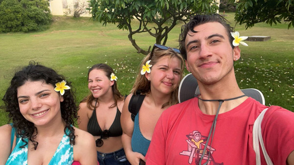 A group of study abroad students with flowers in their hair posing for a photo