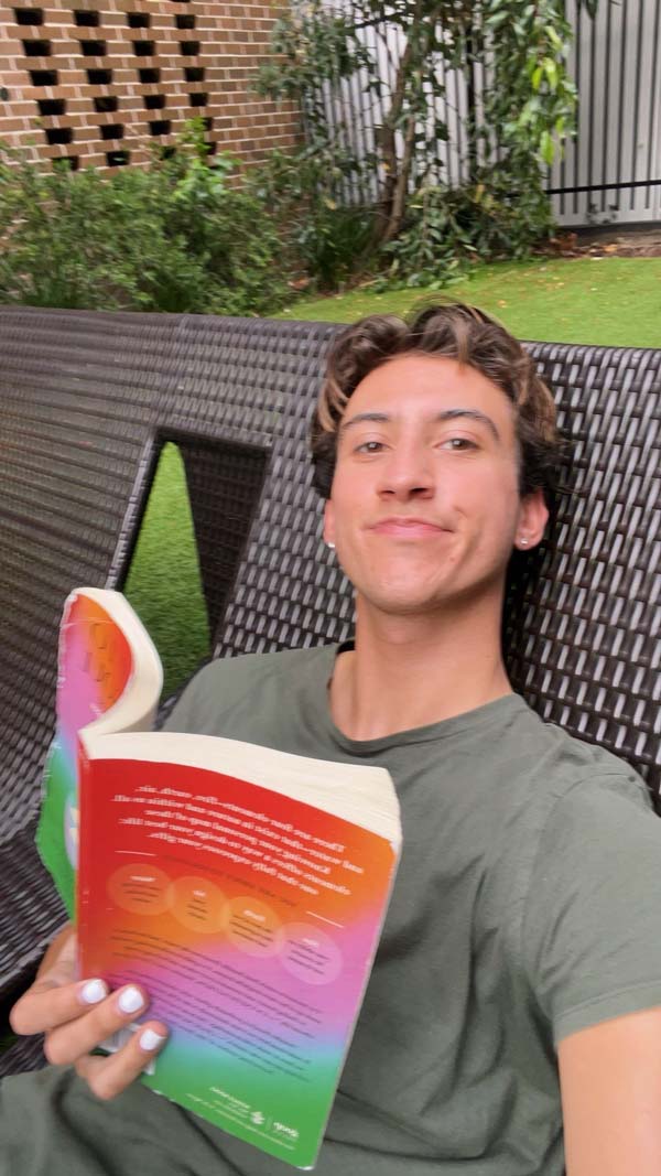 A study abroad student sitting on a chair holding a book