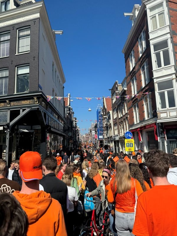 Crowded Amsterdam street with people wearing orange