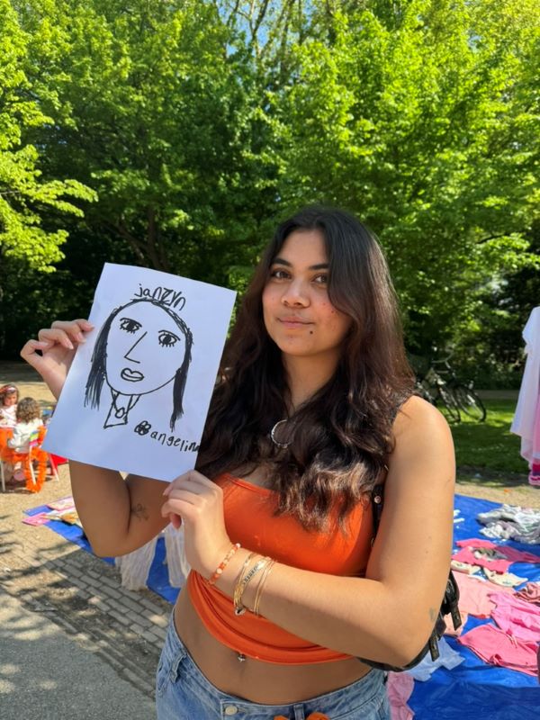 Study abroad student posing for photo with a self portrait