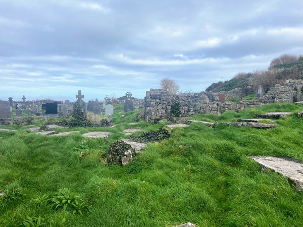 A graveyard with stone ruins and grass