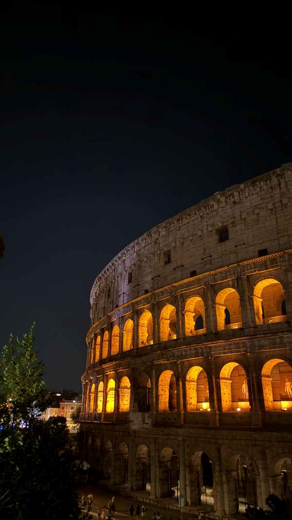 A large stone landmark lit up brightly at nighttime