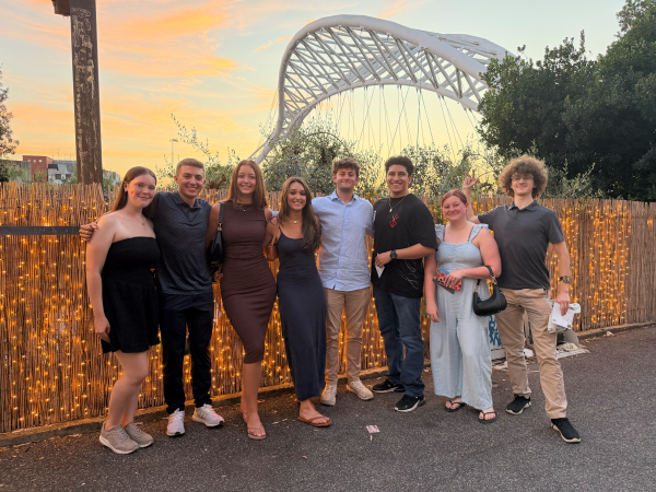 A group of study abroad students standing outdoors and smiling at the camera