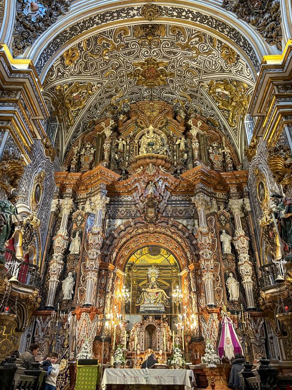 An extremely intricately decorated altar inside a cathedral