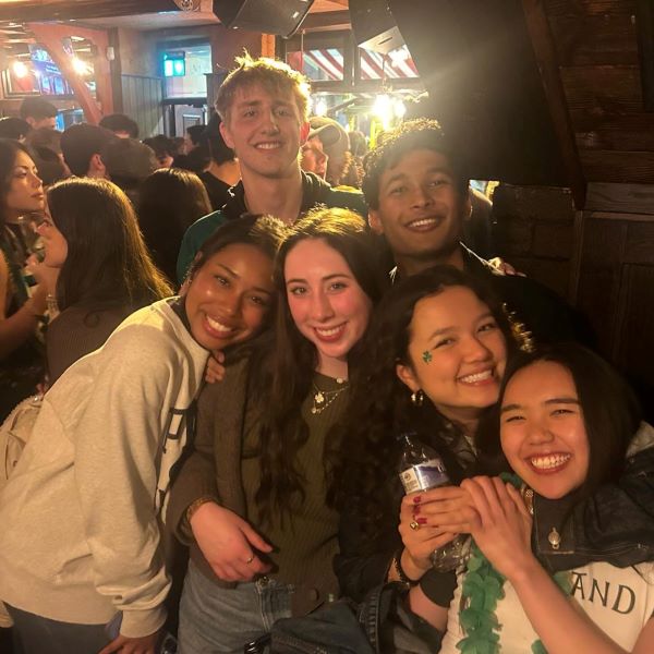 Six study abroad students grouped together in an indoor space and smiling at the camera
