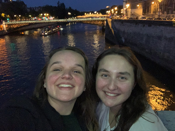 Two study abroad students taking a selfie along a river