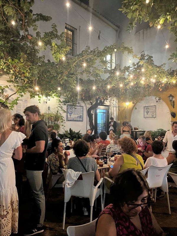 Patio at La Peña with people enjoying drinks and tapas