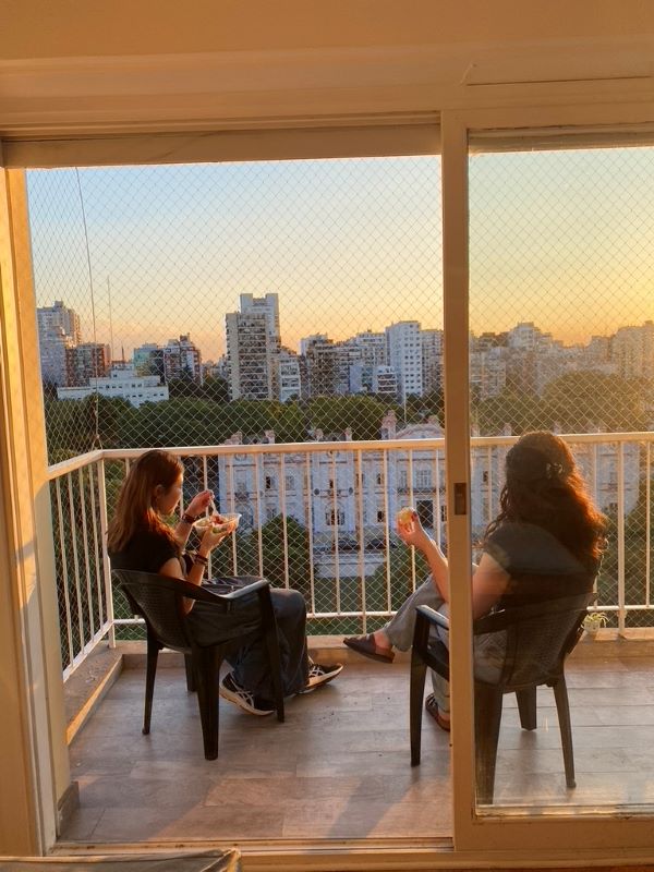 Two study abroad students eating outside on patio overlooking city