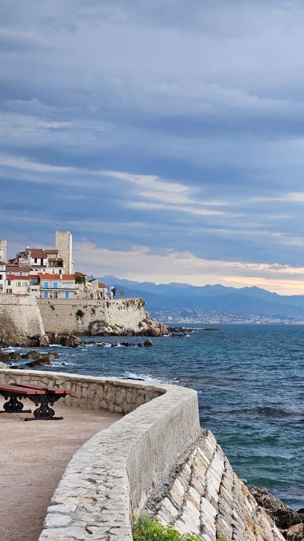 A view of a large body of water with a stone coastline to the left