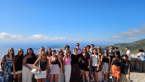 A large group of study abroad students posted for a photo outdoors