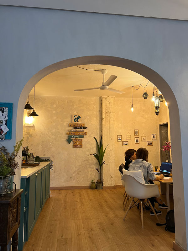 An office in which two people are sitting at a desk looking at a laptop