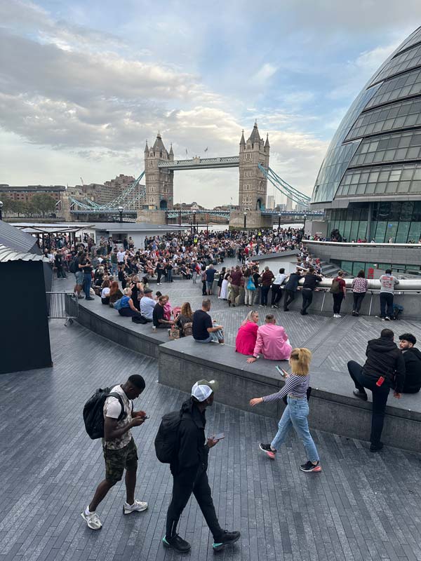 Photo of London with people lounging outside.