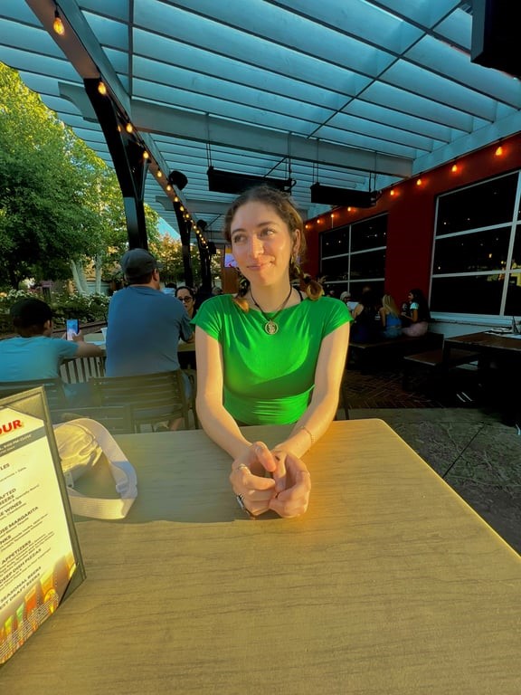 person sitting at a table wearing green top