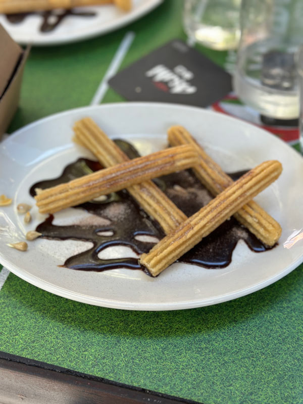 A plate of churros with chocolate sauce