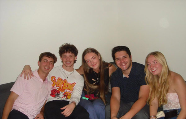 A group of study abroad students sitting and posing for a photo