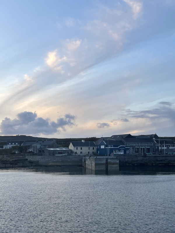 Image of houses on the water of port in Inis Mor with sunset