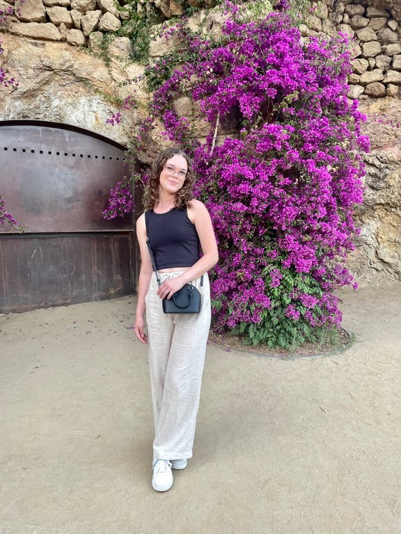 A person standing in front of purple flowers