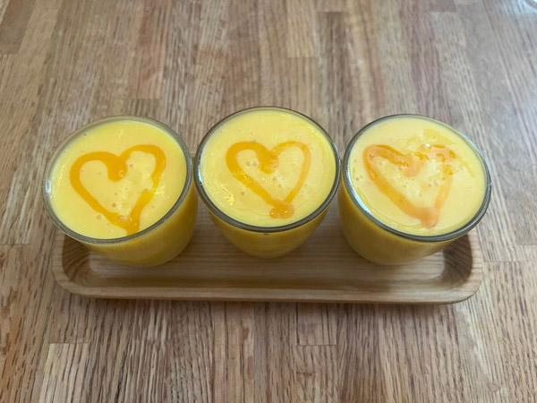 A group of yellow drinks with hearts drawn on them