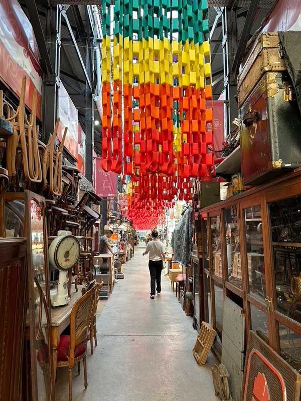 A person as seen from behind walking down an aisle in an outdoor market