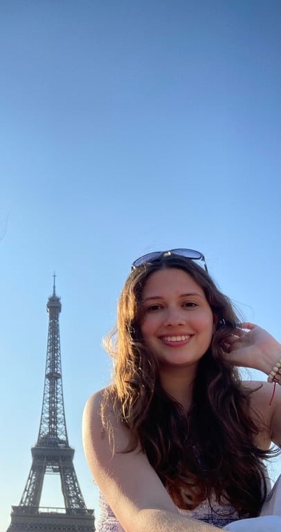 A person smiling with a tower in the background