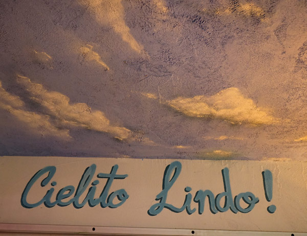 A sign with clouds in the sky