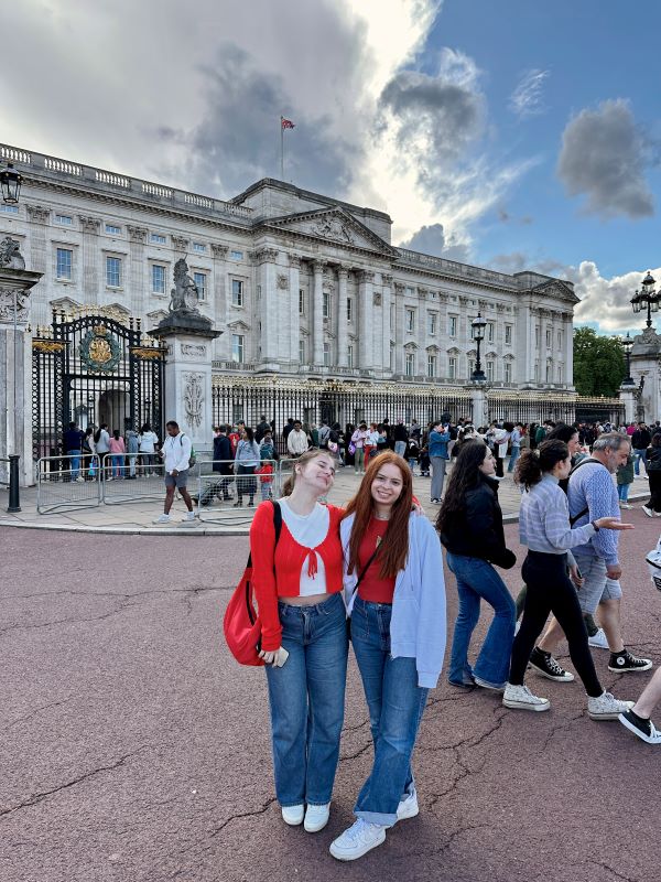 Two study abroad students posing for photo in front of Buckingham Palace
