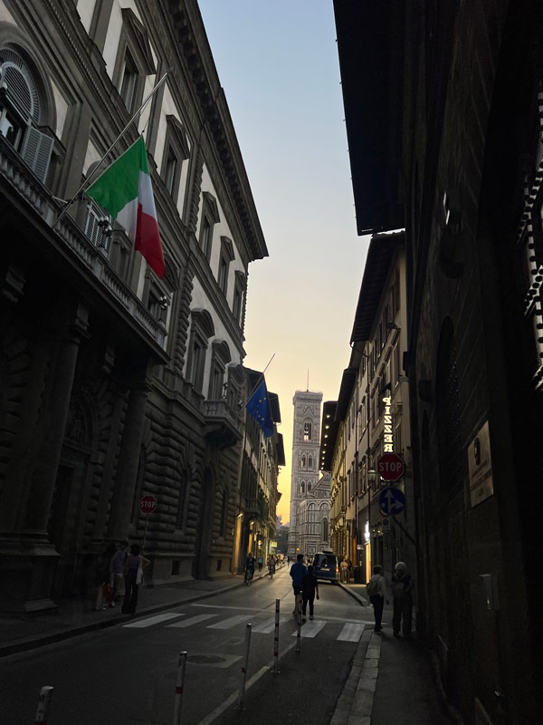 a sunset behind Italian buildings on the street